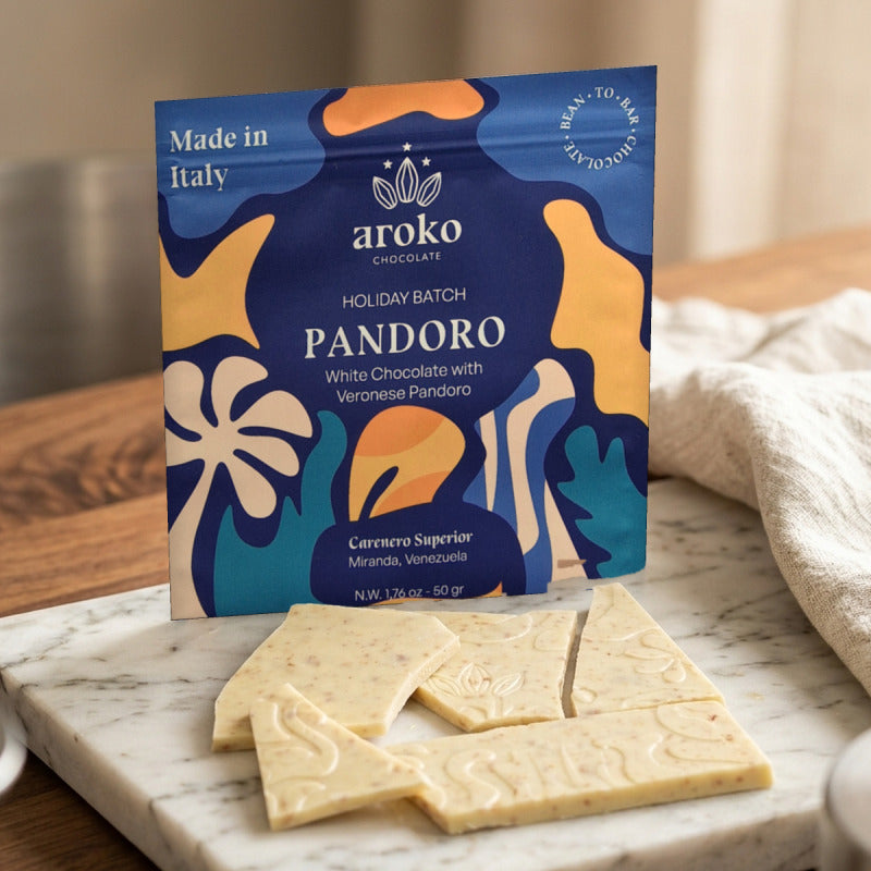 Confezione e pezzi della tavoletta di cioccolato bianco con Pandoro Aroko 50 g in scena ambientata