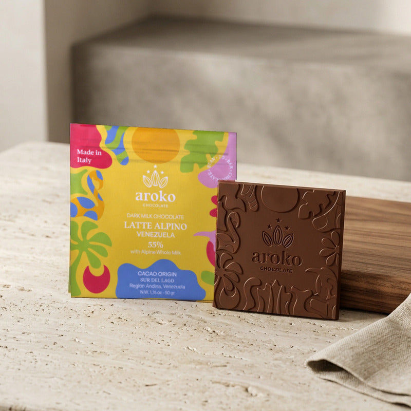 Confezione e tavoletta di cioccolato al latte scuro Latte Alpino 55% Aroko 50 g in scena ambientata