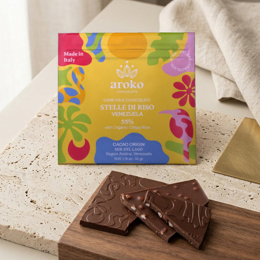 Confezione e pezzi della tavoletta Stelle di Riso al latte scuro 55% con riso soffiato Aroko 50 g in scena ambientata